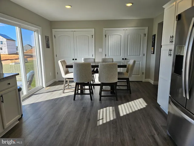 a view of a dining room with furniture a rug and wooden floor