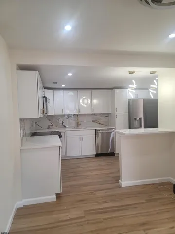a kitchen with a sink cabinets and wooden floor