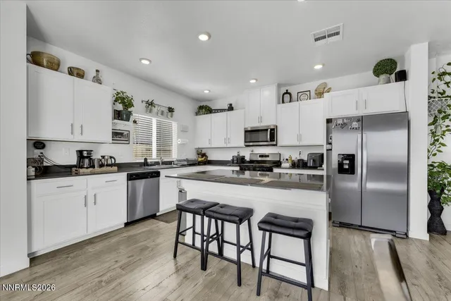 a kitchen with refrigerator a stove and chairs