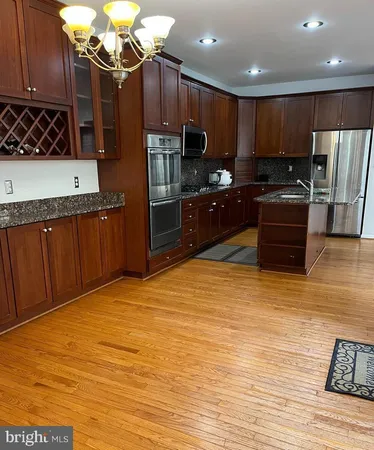 a kitchen with stainless steel appliances wooden cabinets a stove top oven a sink and dishwasher