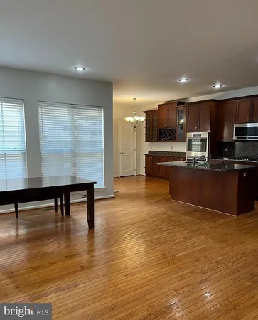 a view of kitchen with kitchen island microwave and wooden floor