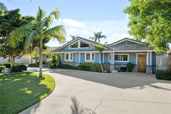 a front view of a house with a yard and potted plants