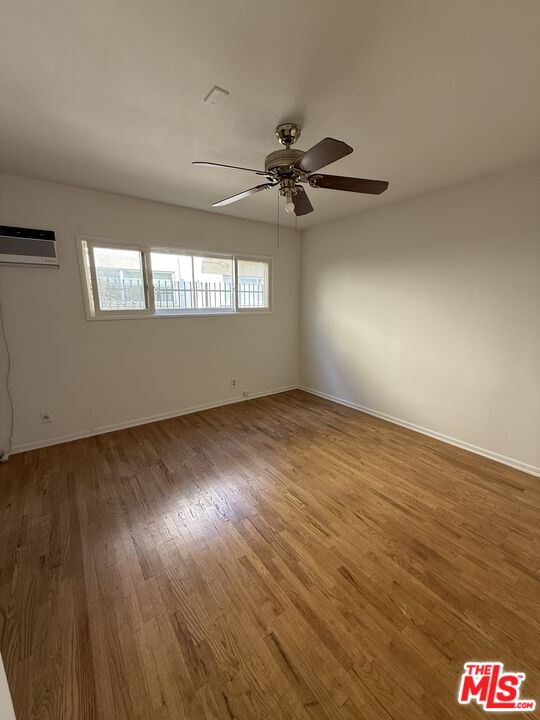 5719 Tilden Avenue, Unit A Sherman Oaks, CA 91401 - Photo 4 of 11 an empty room with wooden floor fan and windows