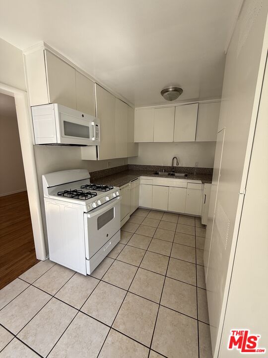 5719 Tilden Avenue, Unit A Sherman Oaks, CA 91401 - Photo 9 of 11 a kitchen with a stove a sink and a refrigerator