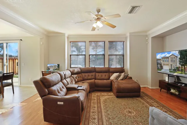 a kitchen with stainless steel appliances granite countertop a refrigerator a stove and a dining table with wooden floors