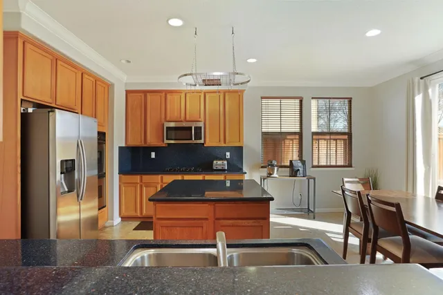 a kitchen with stainless steel appliances granite countertop a refrigerator and a stove