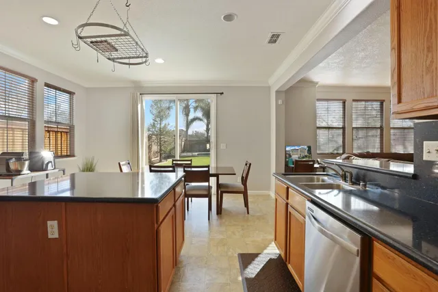a large kitchen with kitchen island a stove a sink a dining table and chairs