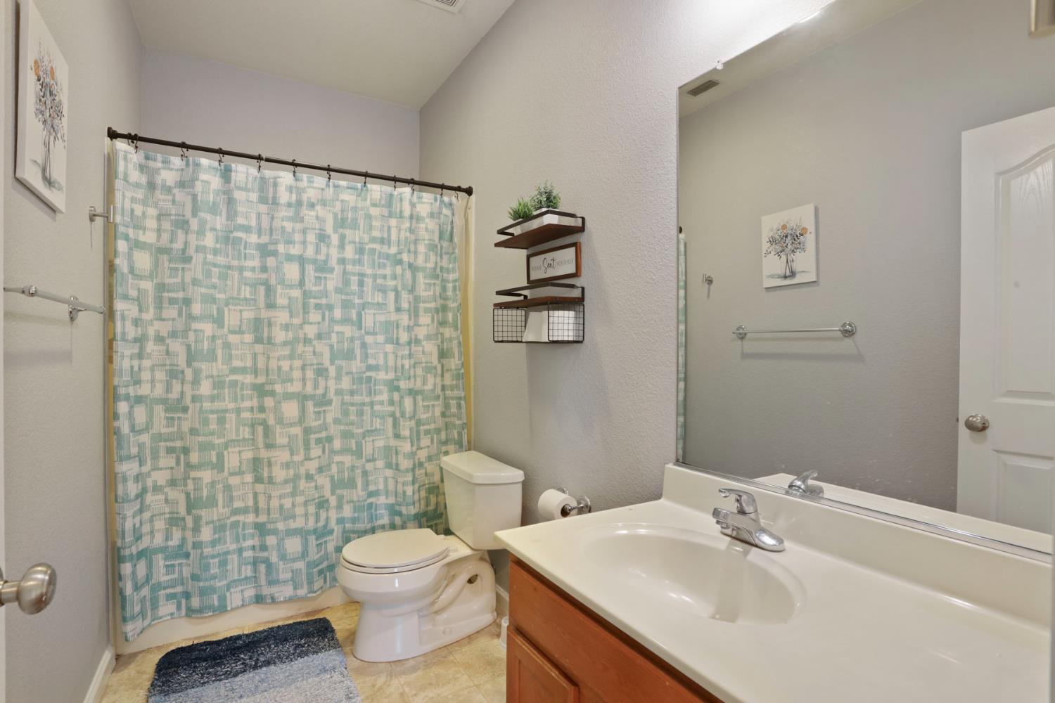 3144 Sweet Lilac Way Stockton, CA 95209 - Photo 48 of 76 a bathroom with a sink a toilet and shower curtain