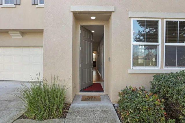 a view of a hallway with wooden floor and a bathroom