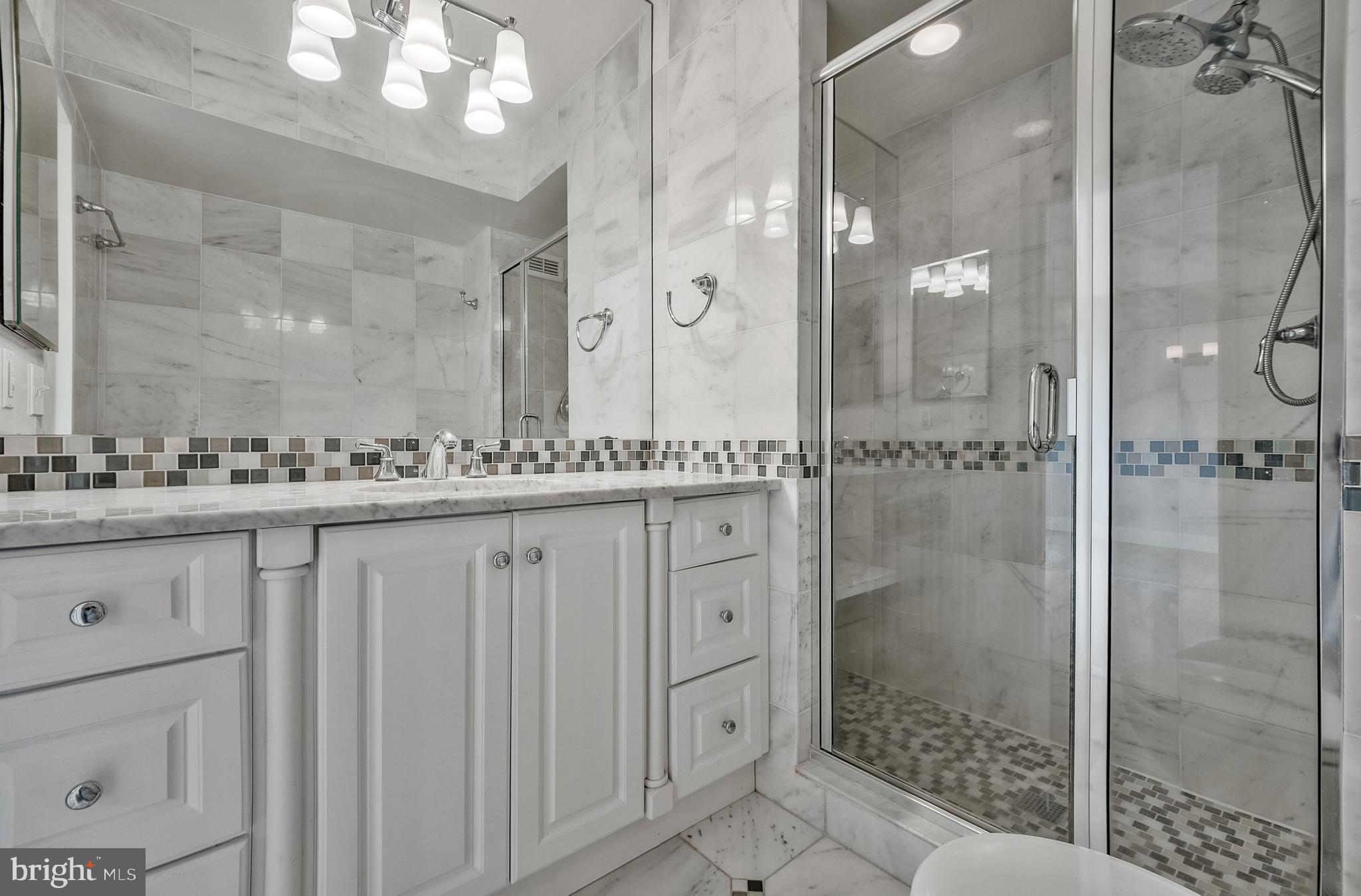 5101 River Road, Unit 618 Bethesda, MD 20816 - Photo 19 of 46 a bathroom with a granite countertop sink a mirror and a shower