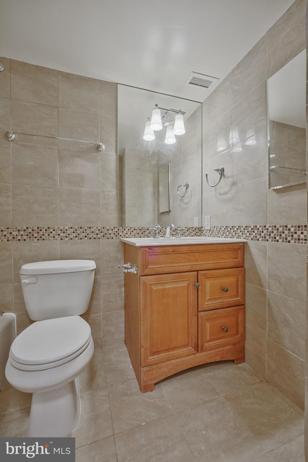 5101 River Road, Unit 618 Bethesda, MD 20816 - Photo 27 of 46 a bathroom with a granite countertop toilet sink and mirror