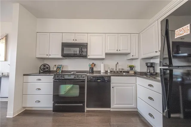 a kitchen with white cabinets and appliances
