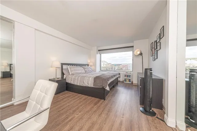 a bedroom with a bed couch and a large window