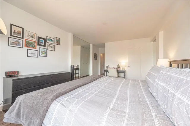 a bedroom with a large bed and painting on the wall