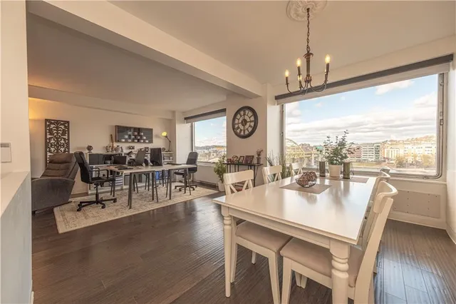 a dining room with wooden floor a chandelier a wooden table and chairs