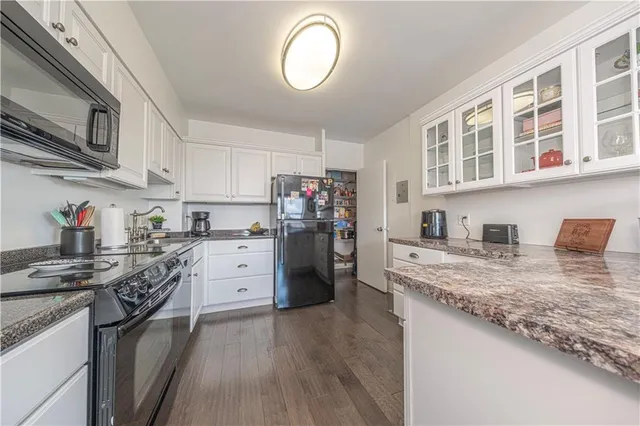 a kitchen with stainless steel appliances granite countertop a lot of counter space and wooden floors