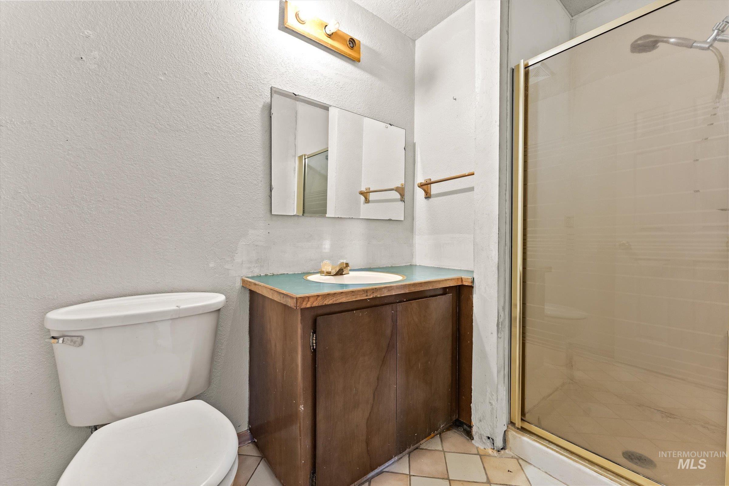 6267 Deer Flat Road Nampa, ID 83686 - Photo 12 of 50 Bathroom featuring a shower stall, a textured wall, and vanity