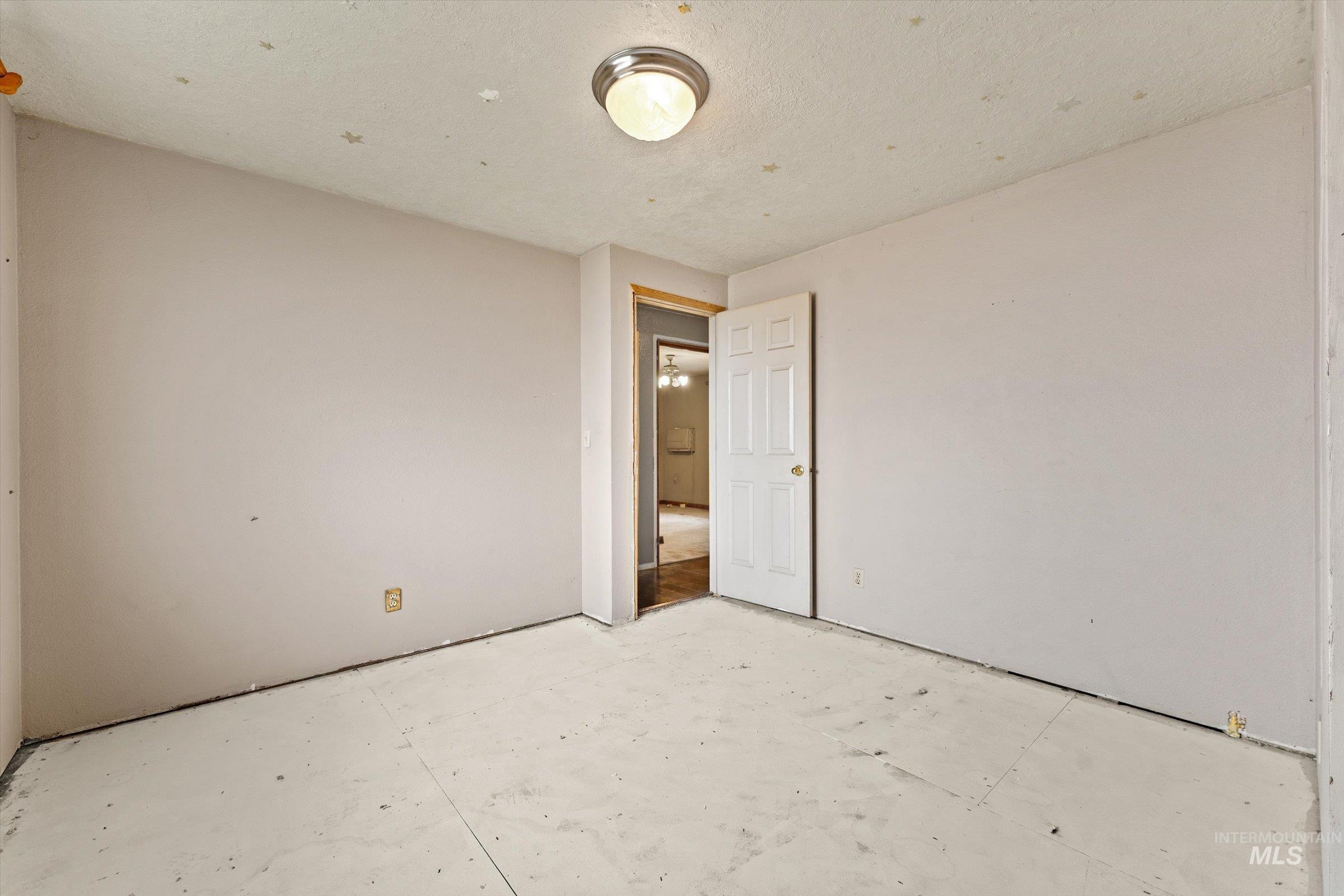 6267 Deer Flat Road Nampa, ID 83686 - Photo 16 of 50 Unfurnished bedroom with unfinished concrete floors and a textured ceiling