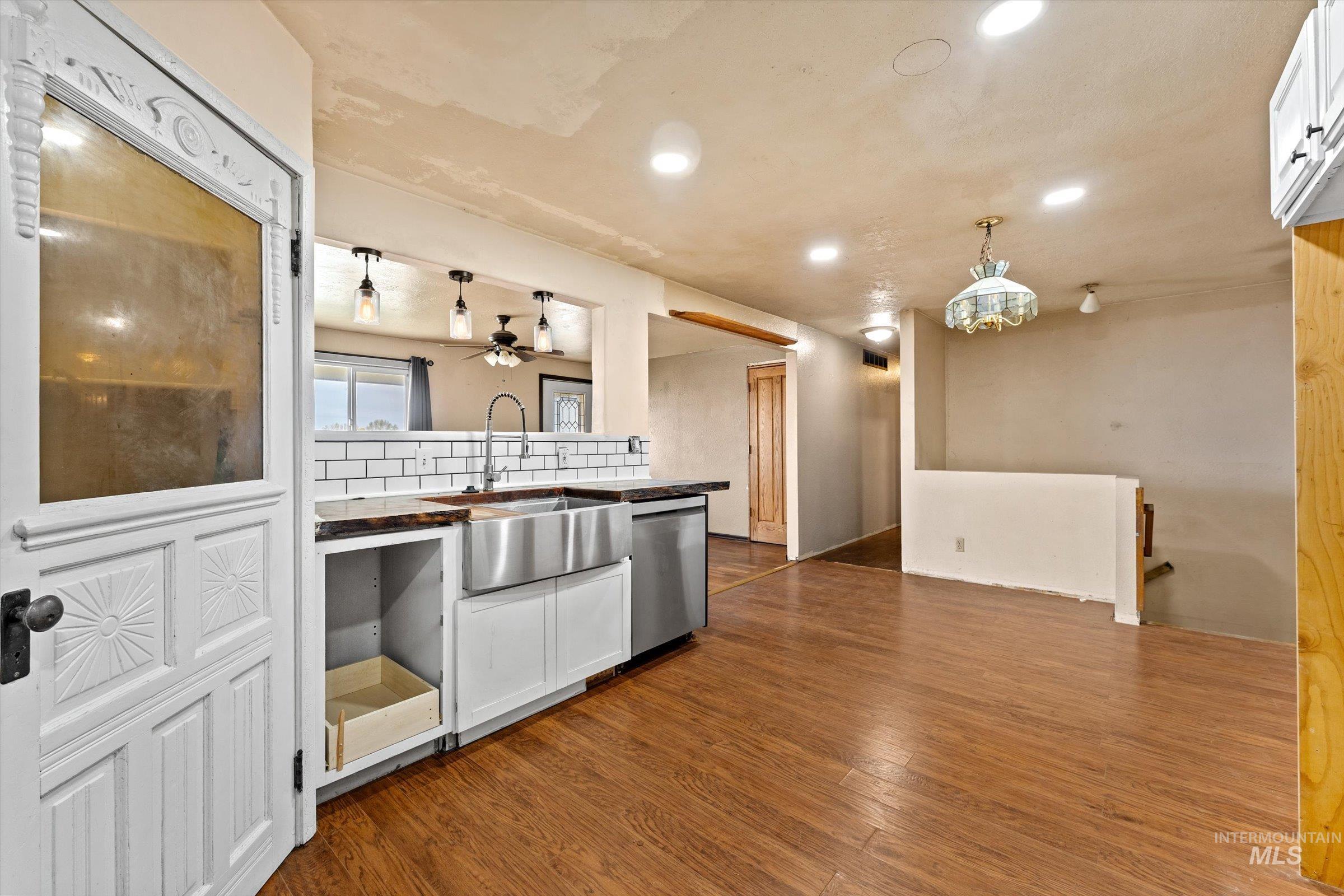 6267 Deer Flat Road Nampa, ID 83686 - Photo 2 of 50 Kitchen featuring backsplash, a ceiling fan, white cabinetry, and dark wood finished floors