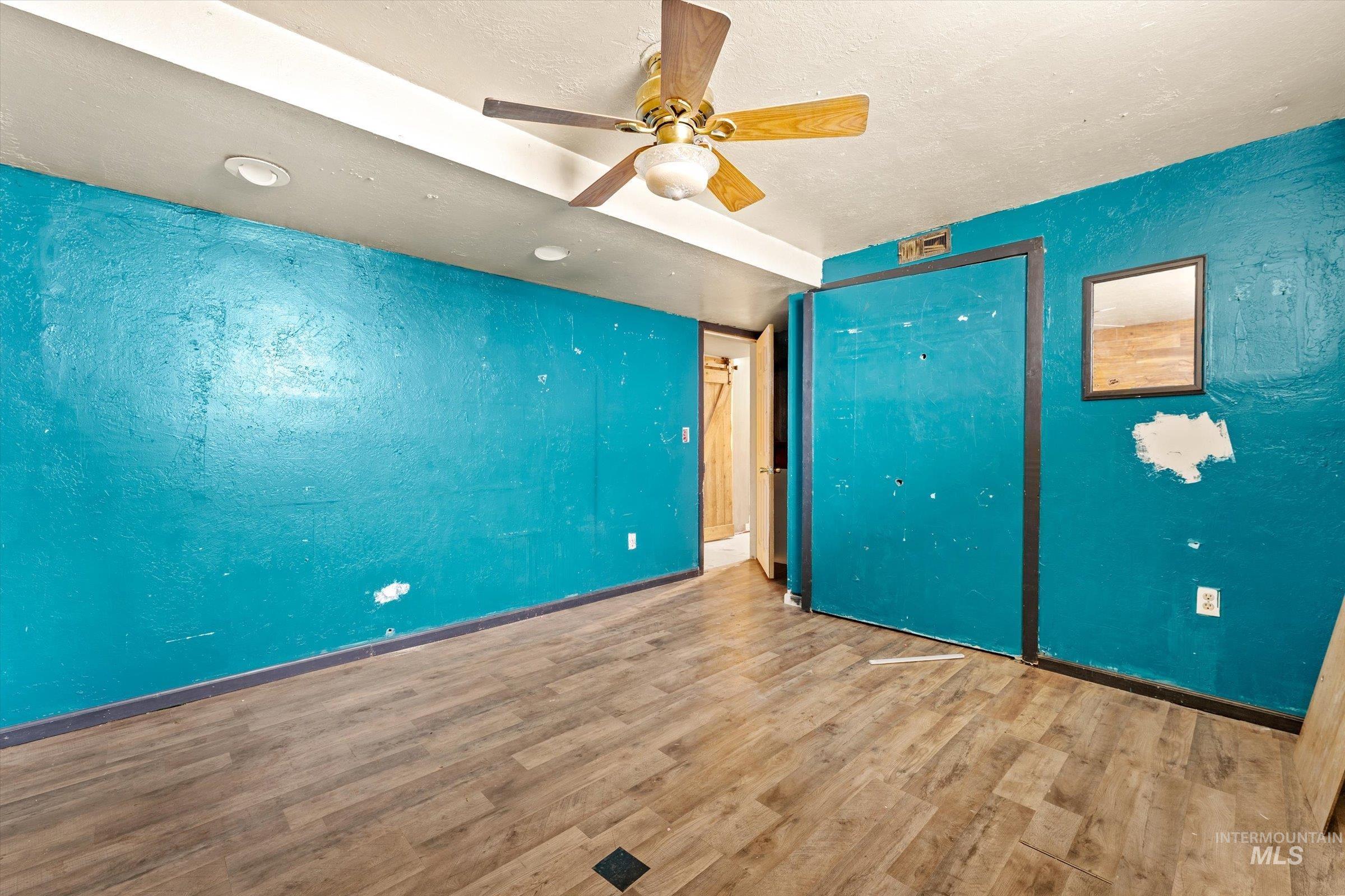 6267 Deer Flat Road Nampa, ID 83686 - Photo 23 of 50 Unfurnished bedroom featuring ceiling fan, wood finished floors, and a textured ceiling