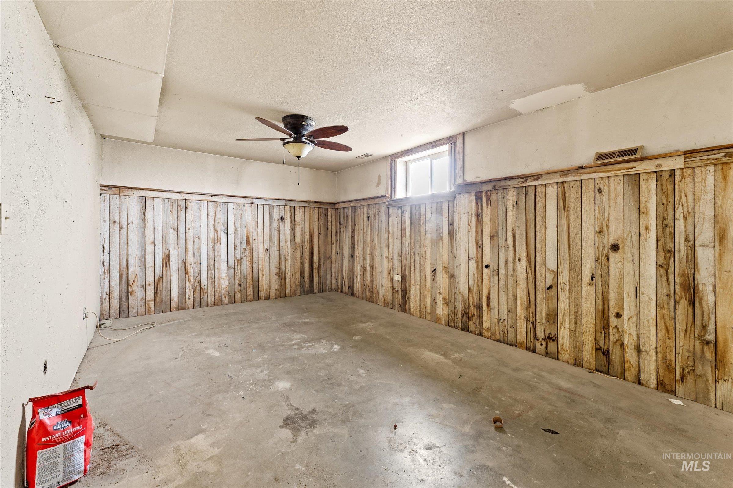 6267 Deer Flat Road Nampa, ID 83686 - Photo 25 of 50 Basement with wooden walls, wainscoting, and a ceiling fan