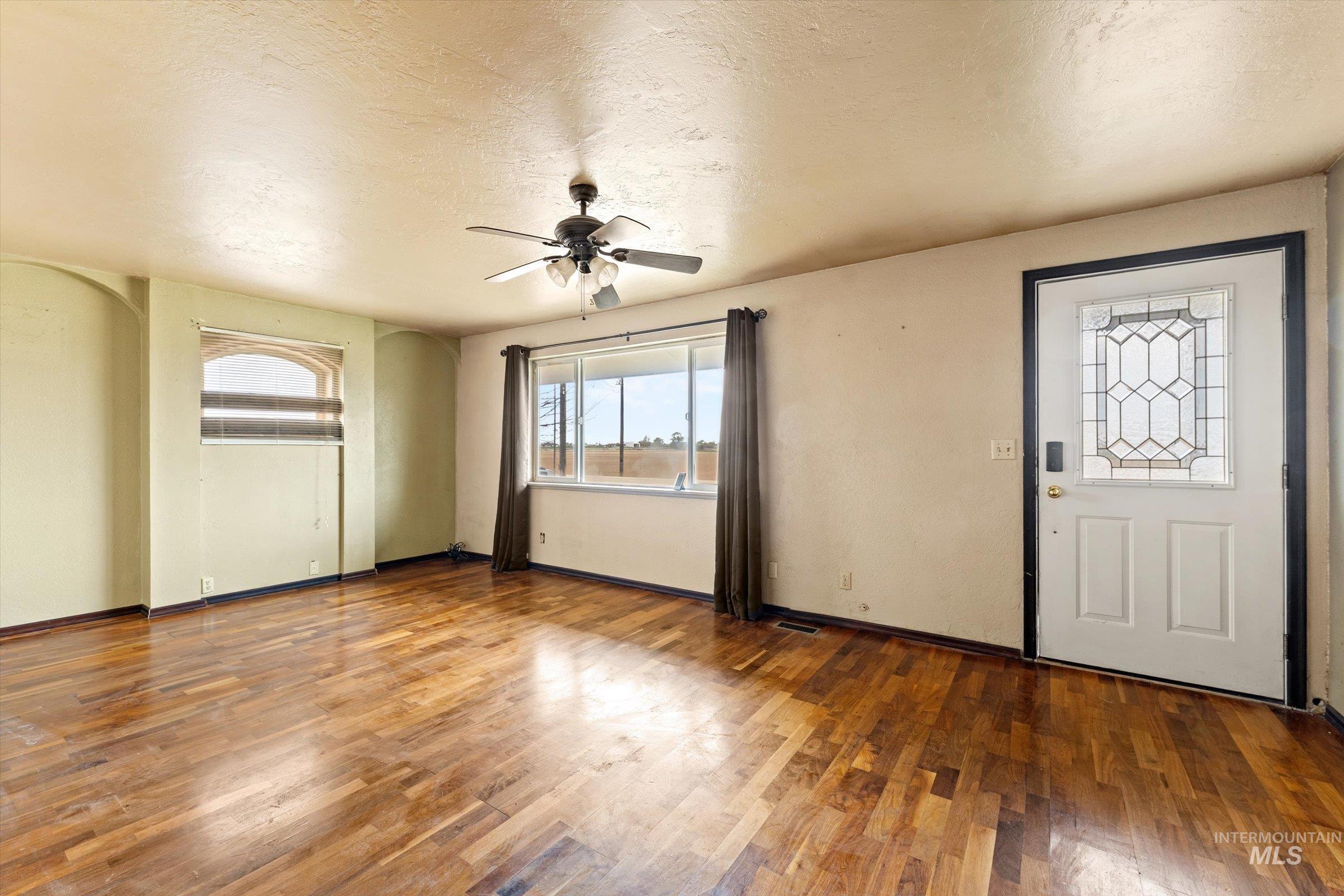6267 Deer Flat Road Nampa, ID 83686 - Photo 7 of 50 Entryway featuring a textured ceiling, dark wood-type flooring, and a ceiling fan