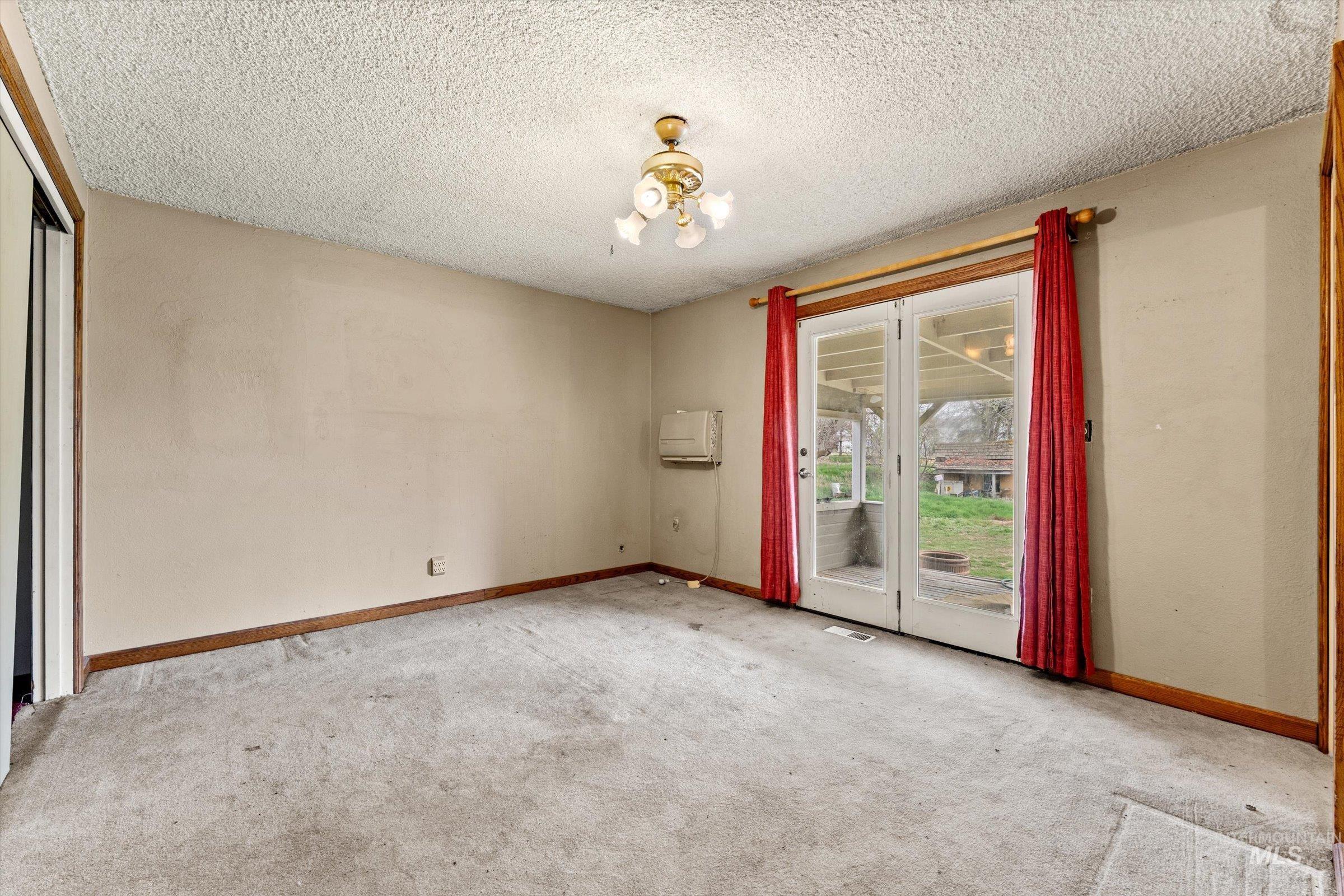 6267 Deer Flat Road Nampa, ID 83686 - Photo 10 of 50 Unfurnished room featuring light carpet and a textured ceiling