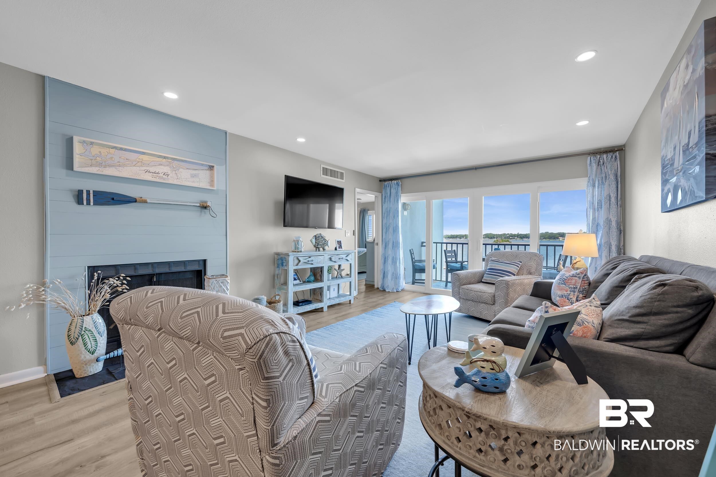 14100 River Road, Unit 211 Pensacola, FL 32507 - Photo 20 of 56 Living area featuring wood-finish flooring, recessed lighting, and a prominent fireplace with a light blue shiplap surround