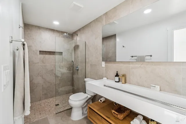 a bathroom with a sink toilet a shower and a mirror