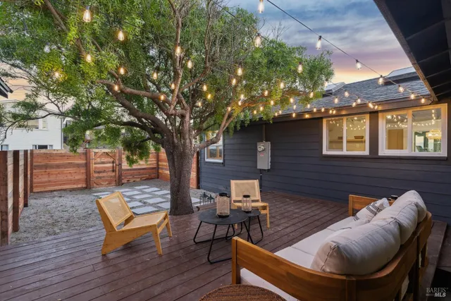 a living room with patio furniture and a large tree