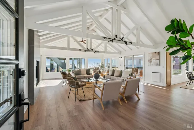 a dining room with wooden floor a chandelier a glass table and chairs