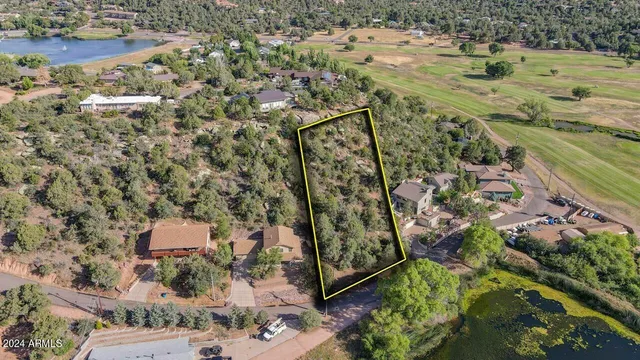 an aerial view of a house with a yard and lake view