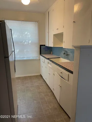 a kitchen with a sink and a refrigerator