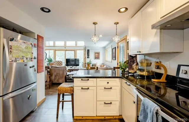 a kitchen with granite countertop a sink stove and refrigerator
