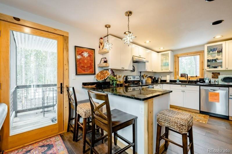 106 Protector Circle Breckenridge, CO 80424 - Photo 14 of 40 a kitchen with granite countertop sink stove and white cabinets with wooden floor