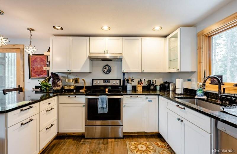 106 Protector Circle Breckenridge, CO 80424 - Photo 15 of 40 a kitchen with kitchen island granite countertop white cabinets sink and white appliances