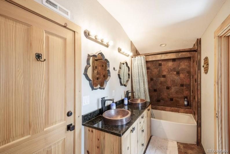 106 Protector Circle Breckenridge, CO 80424 - Photo 29 of 40 a bathroom with a granite countertop sink a mirror a bathtub and shower