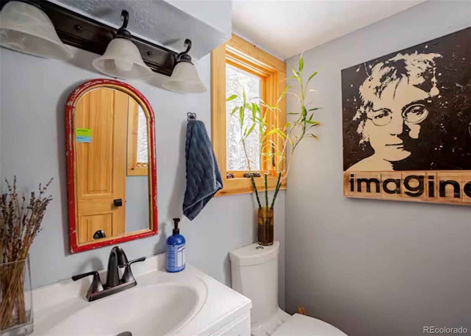 106 Protector Circle Breckenridge, CO 80424 - Photo 10 of 40 a bathroom with a sink a mirror a toilet and a window