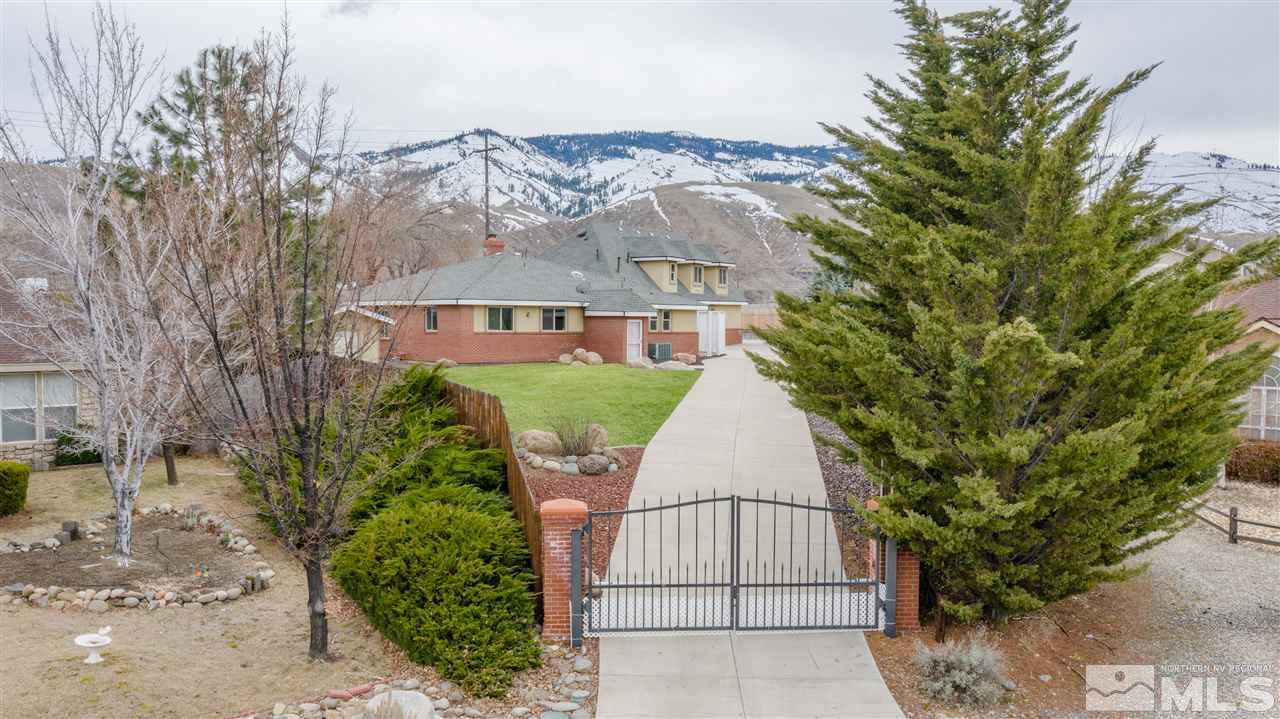 a view of a white house with large trees
