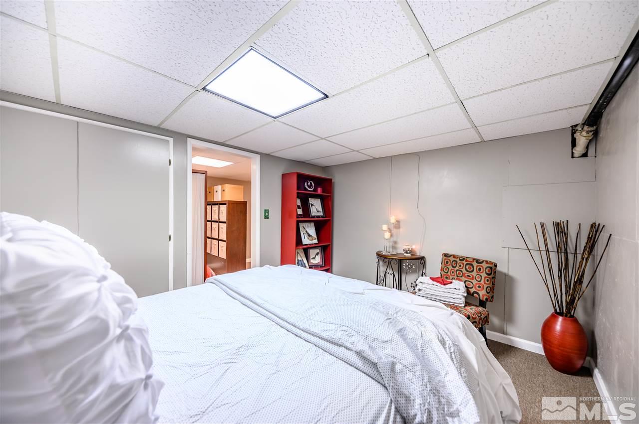 10300 Silva Ranch Road Reno, NV 89523 - Photo 16 of 25 a bedroom with a large bed and a chandelier