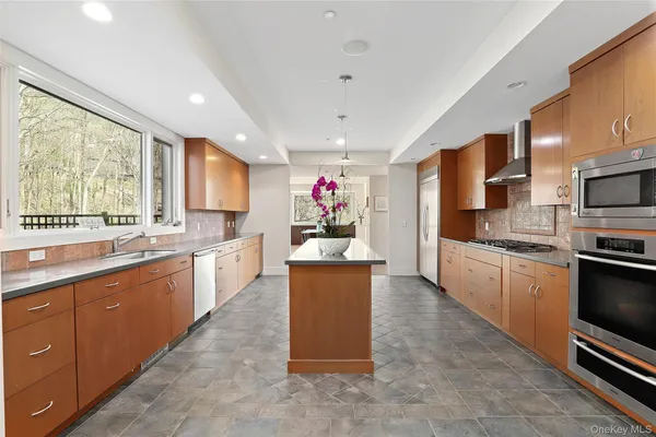a large kitchen with stainless steel appliances kitchen island granite countertop a stove refrigerator and a sink