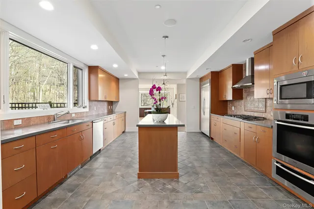 a large kitchen with stainless steel appliances kitchen island granite countertop a stove refrigerator and a sink