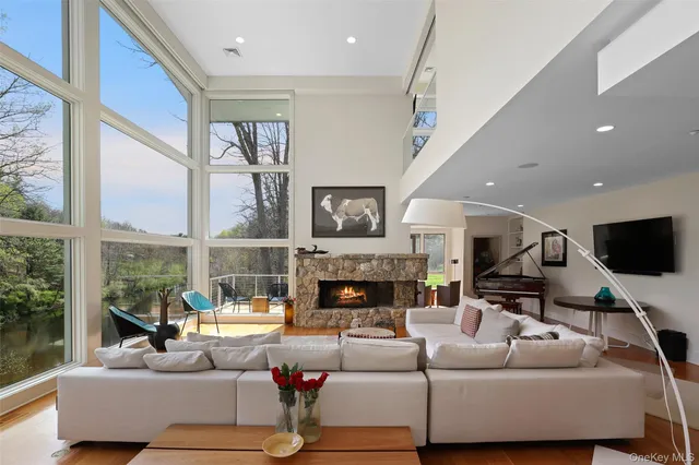 a living room with fireplace furniture and a large window
