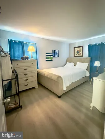 a spacious bedroom with a bed and a lamp on table