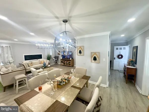 a living room with furniture chandelier and a wooden floor