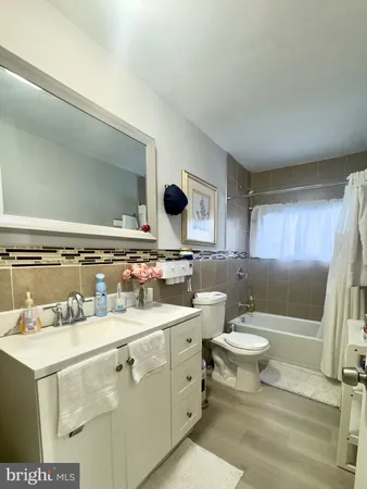 a bathroom with a double vanity sink mirror and toilet
