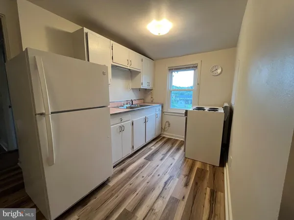 a kitchen with wooden cabinets and refrigerator