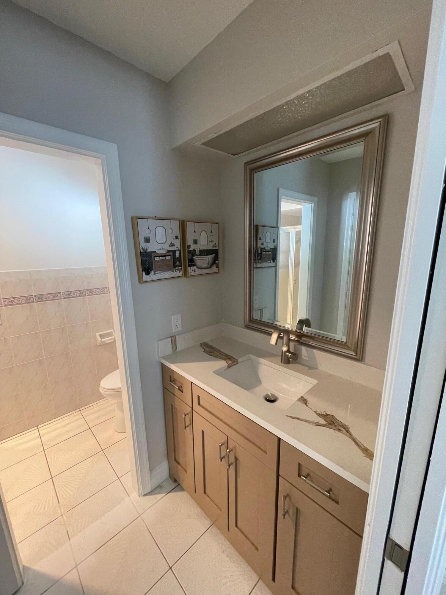 2601 West Carandis Road West Palm Beach, FL 33406 - Photo 5 of 13 a bathroom with a sink a mirror and a vanity