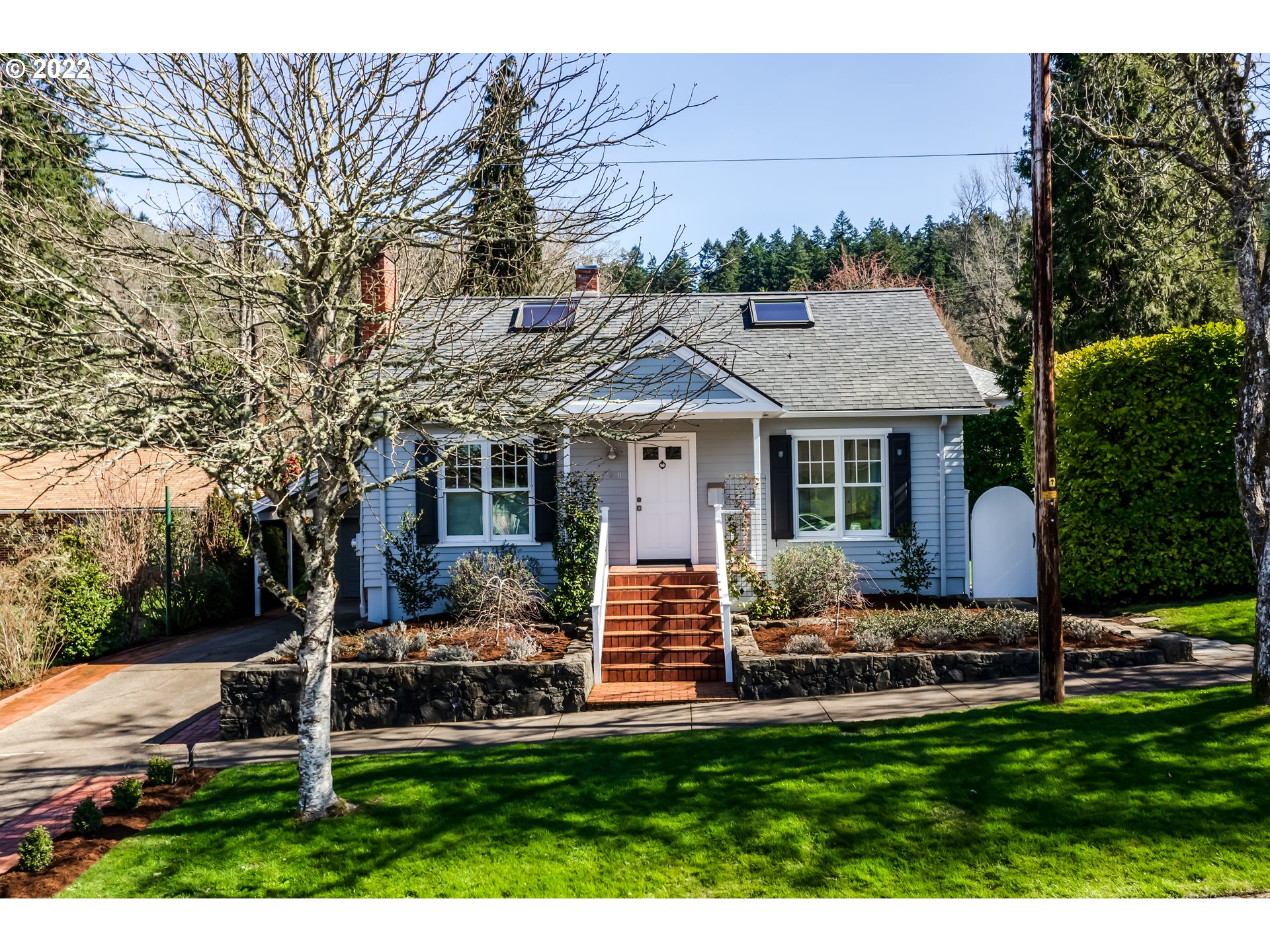 a front view of a house with a yard garden and outdoor seating