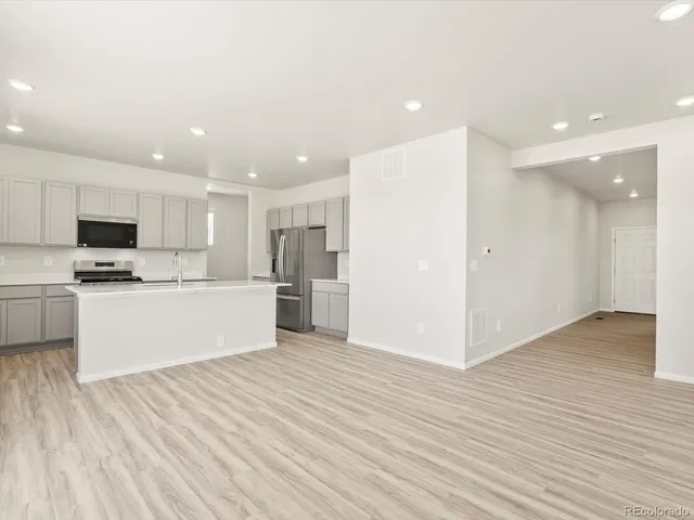 a view of kitchen with granite countertop cabinets and refrigerator